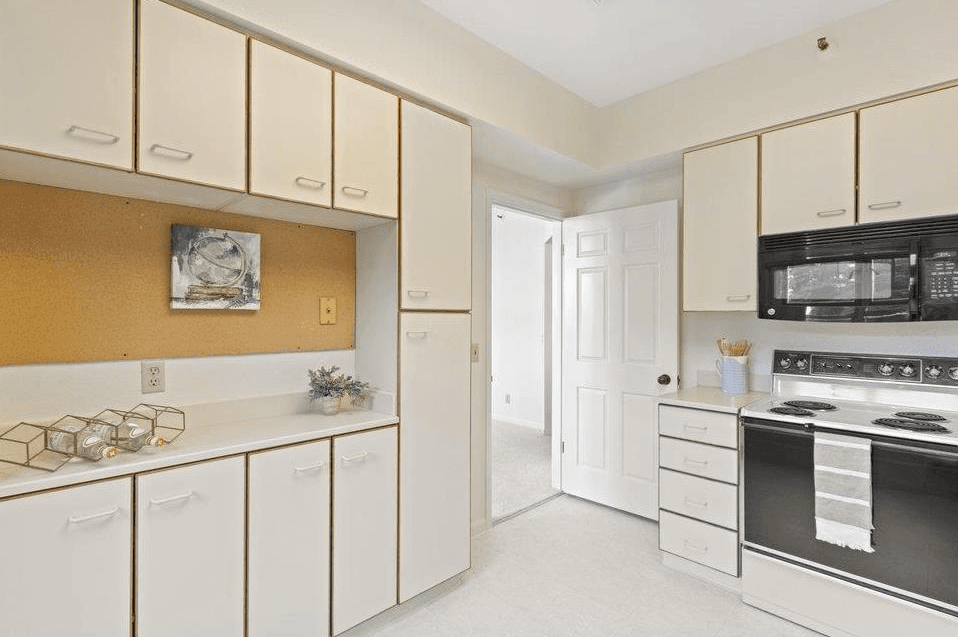 Unit 203 - Kitchen with white cabinets and corkboard detail