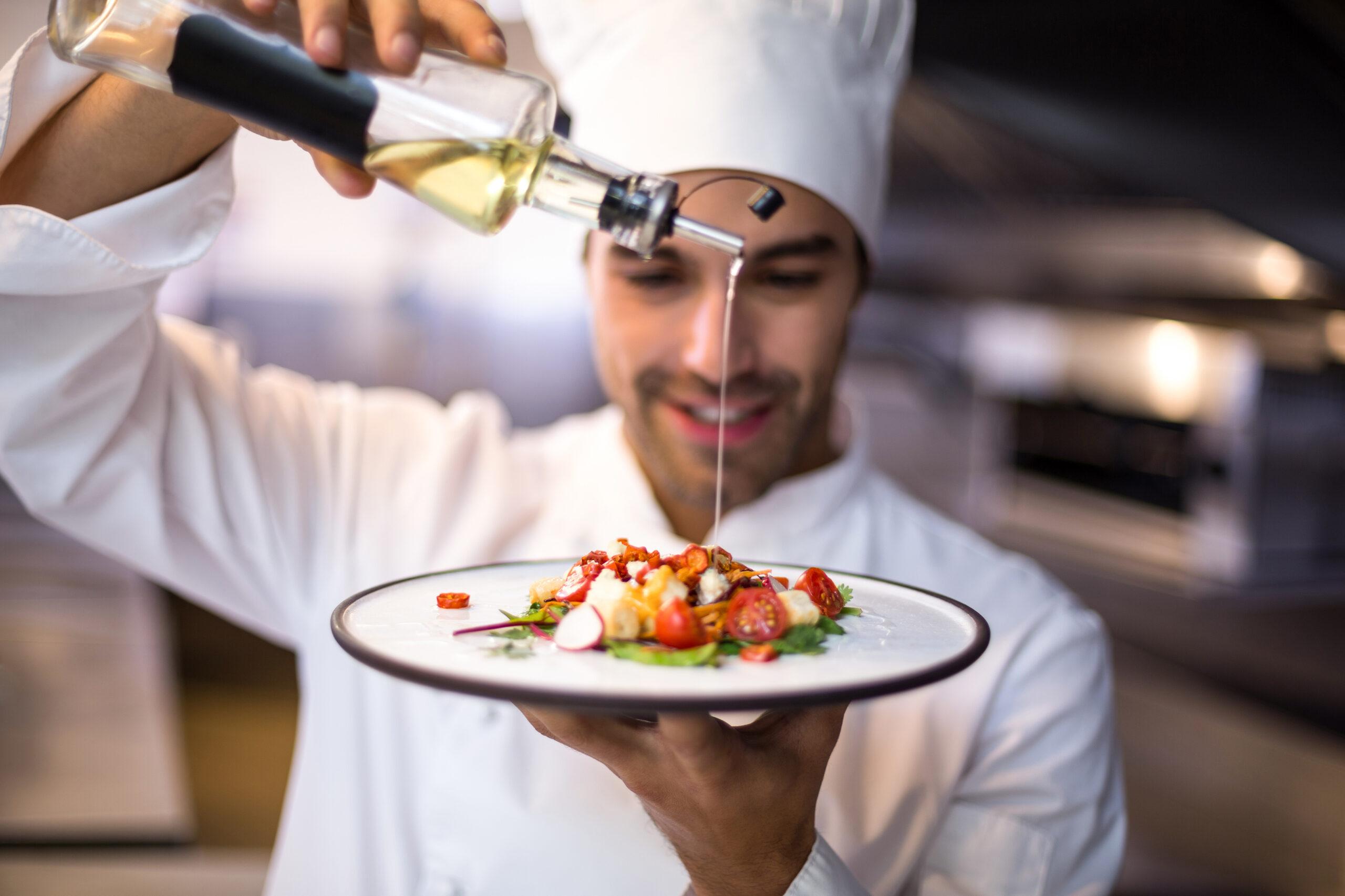 Chef garnishes a meal with olive oil